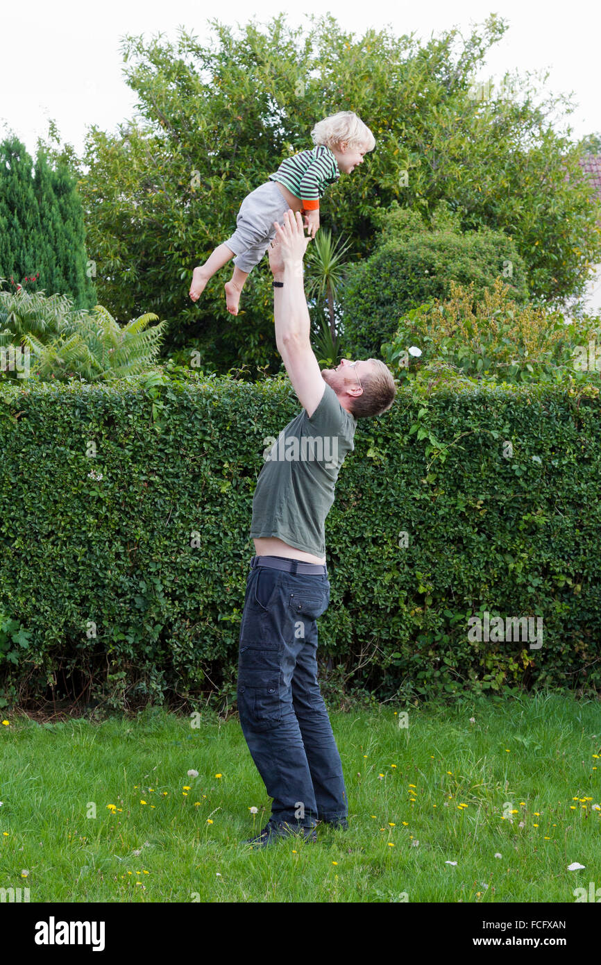 Vater seinen Sohn in die Luft werfen Stockfoto