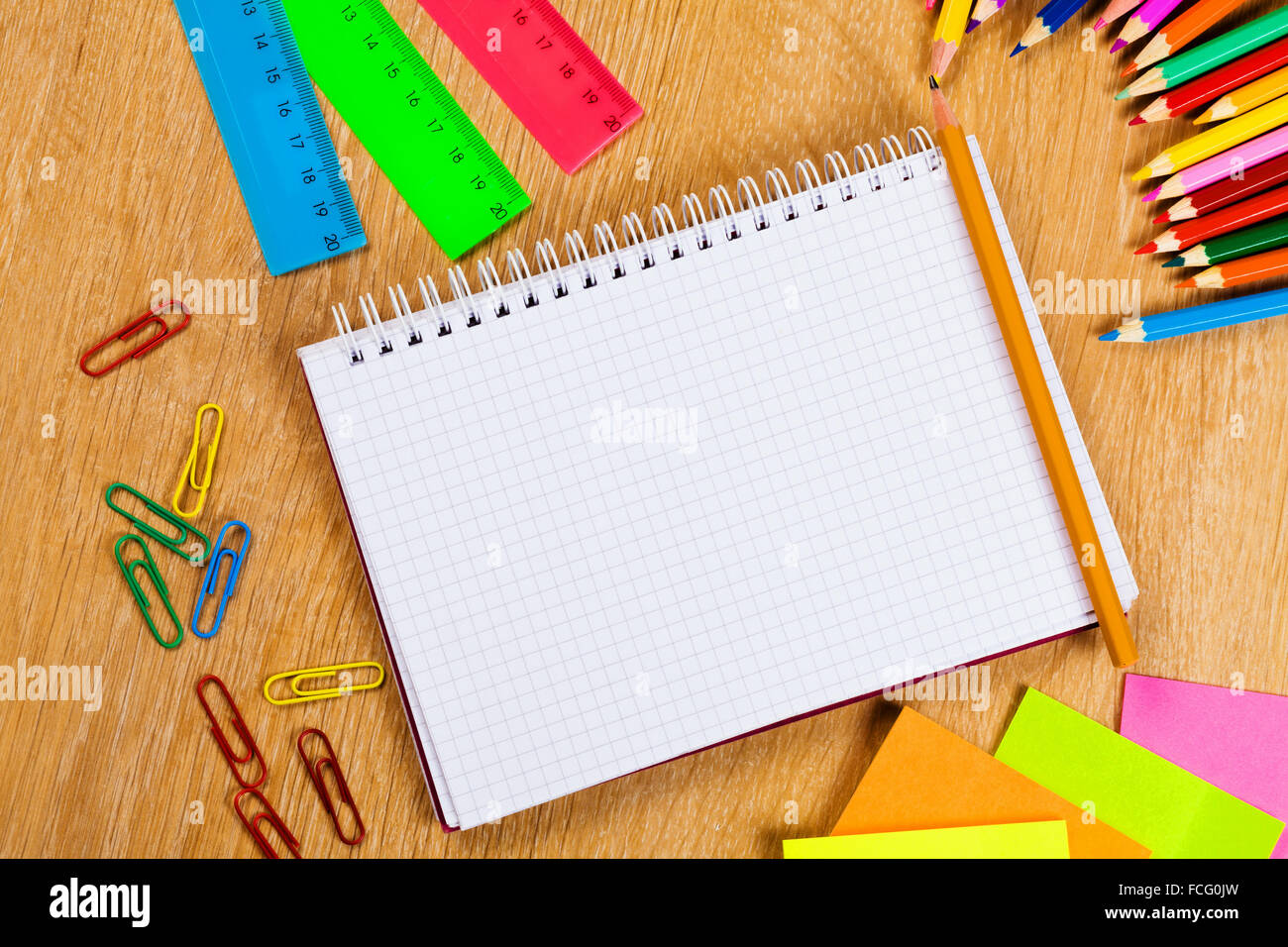 Buntstifte und Notizblock auf Holztisch Stockfoto