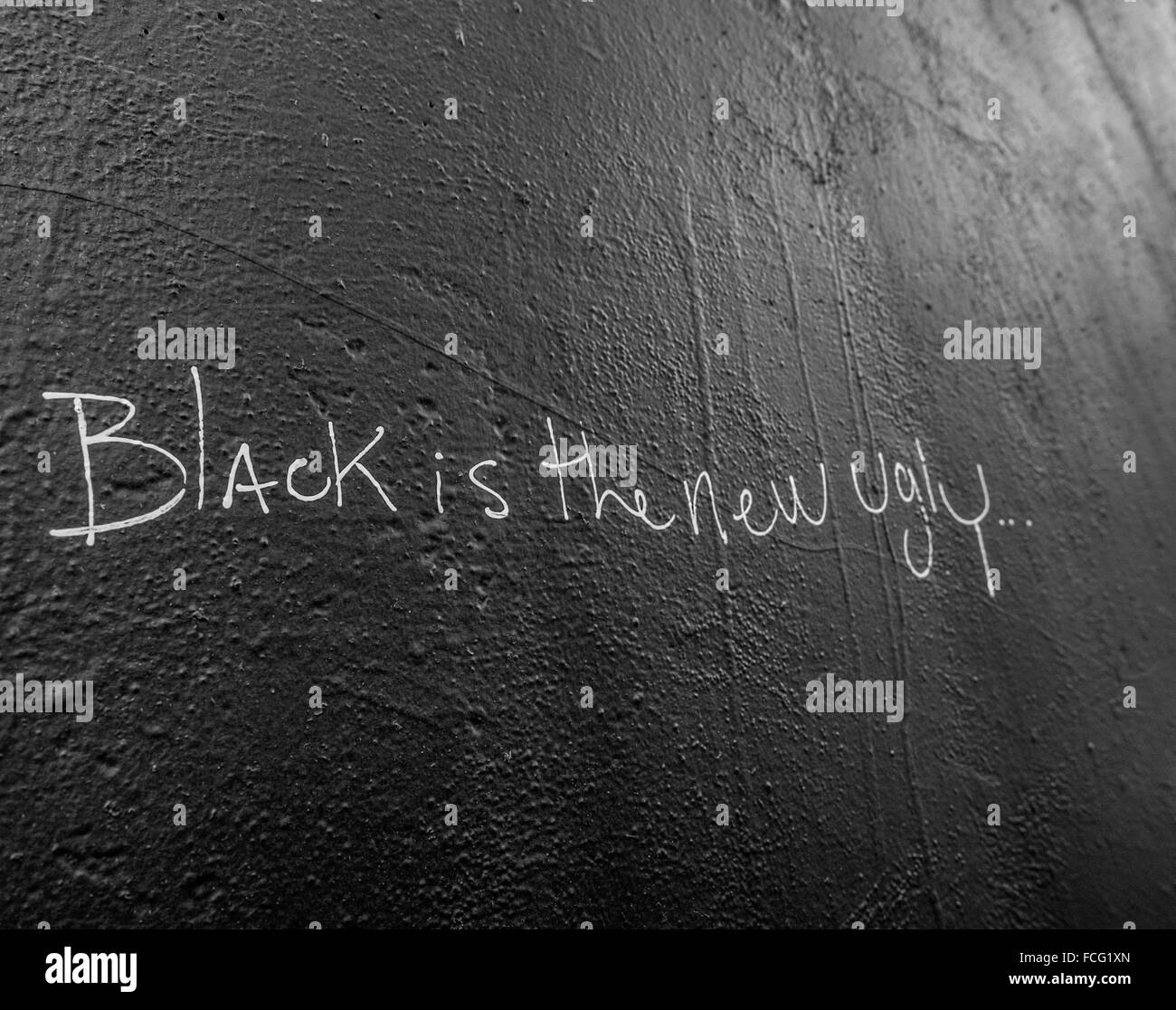 Schwarz bemalte Wand mit weißer Schrift, die sagt