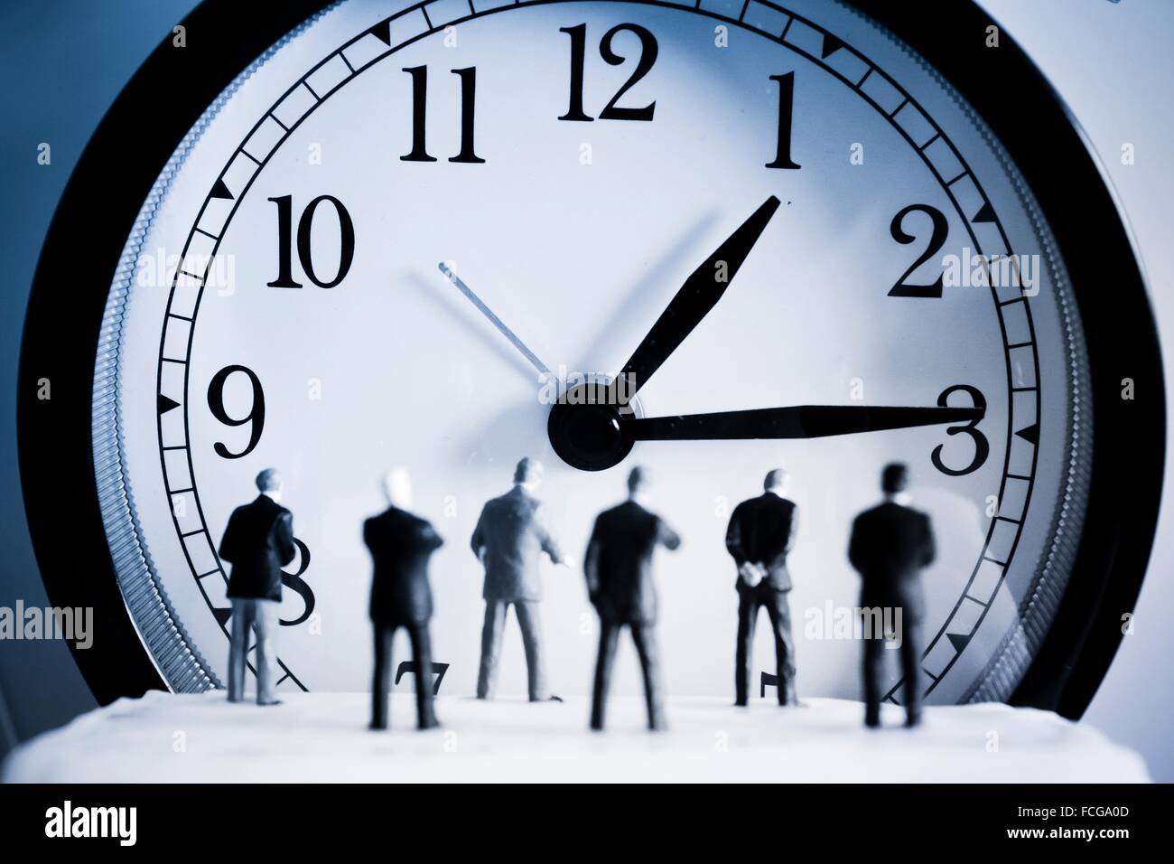 Zeit-Konzept. Männer wieder vor einer Uhr. Stockfoto