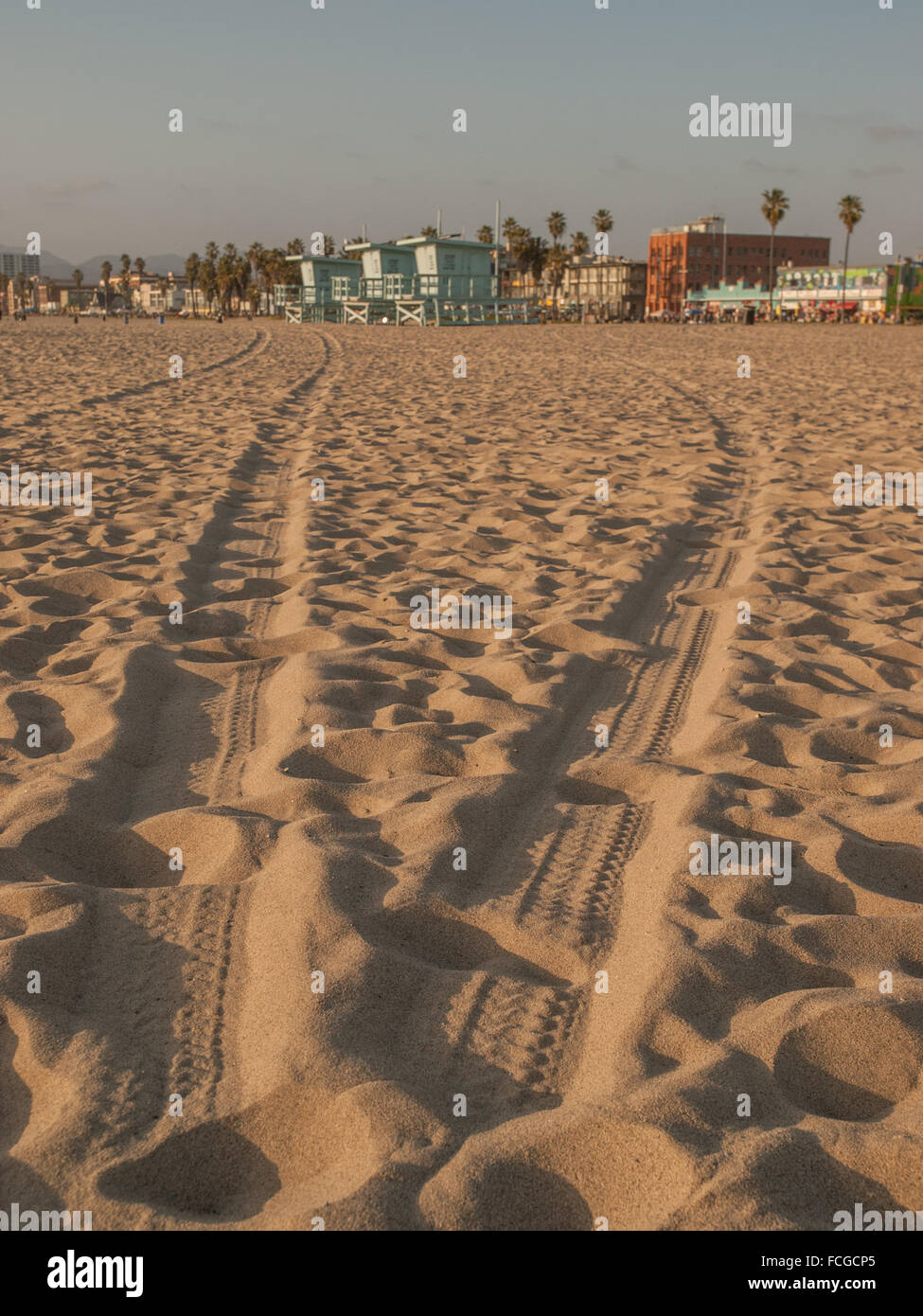Reifenspuren und Fußabdrücke im Sand am verlassenen Venice Beach, Los Angeles, Kalifornien, USA. Stockfoto