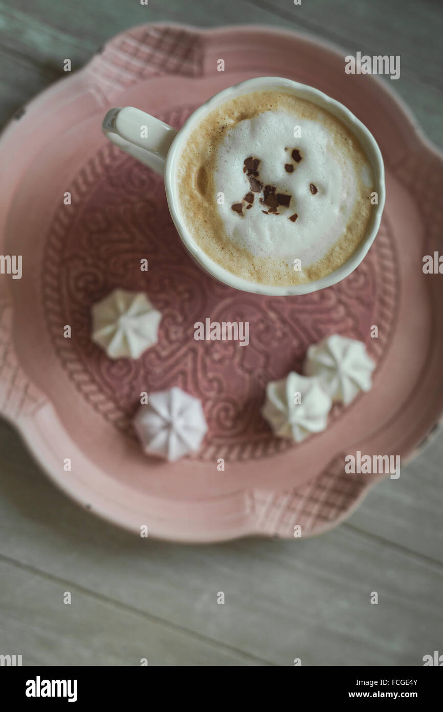 Tasse weißen Kaffee Schokolade rasieren und Meringues auf einem Teller Stockfoto