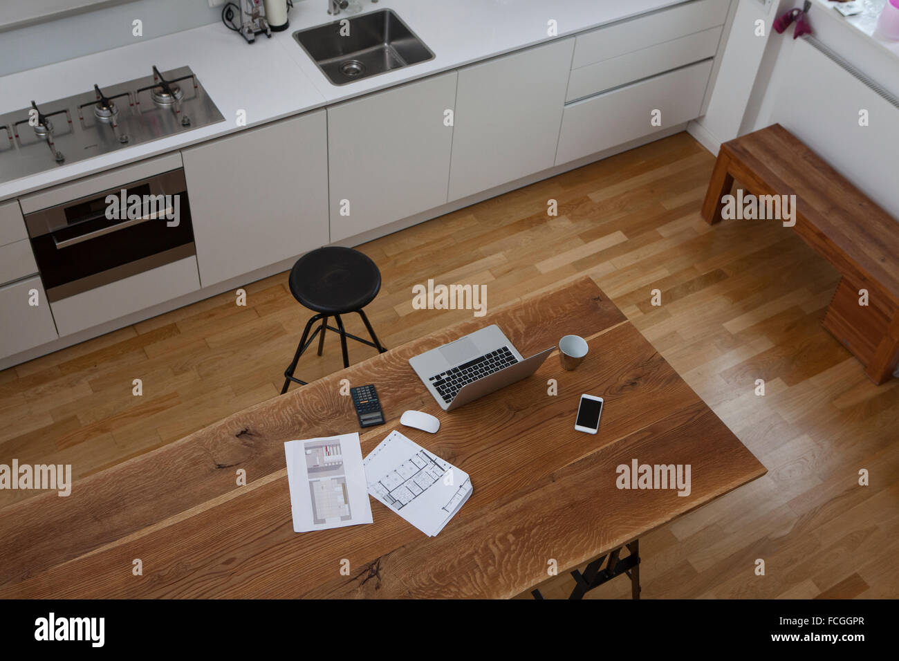Bau-Plan-Laptop-Rechner und Handy am Küchentisch Stockfoto