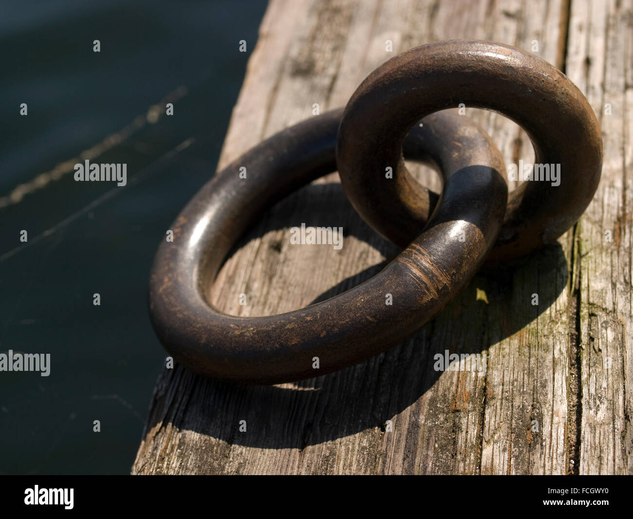 Metallringe auf hölzerne Dock Boot Seil zu binden. Stockfoto