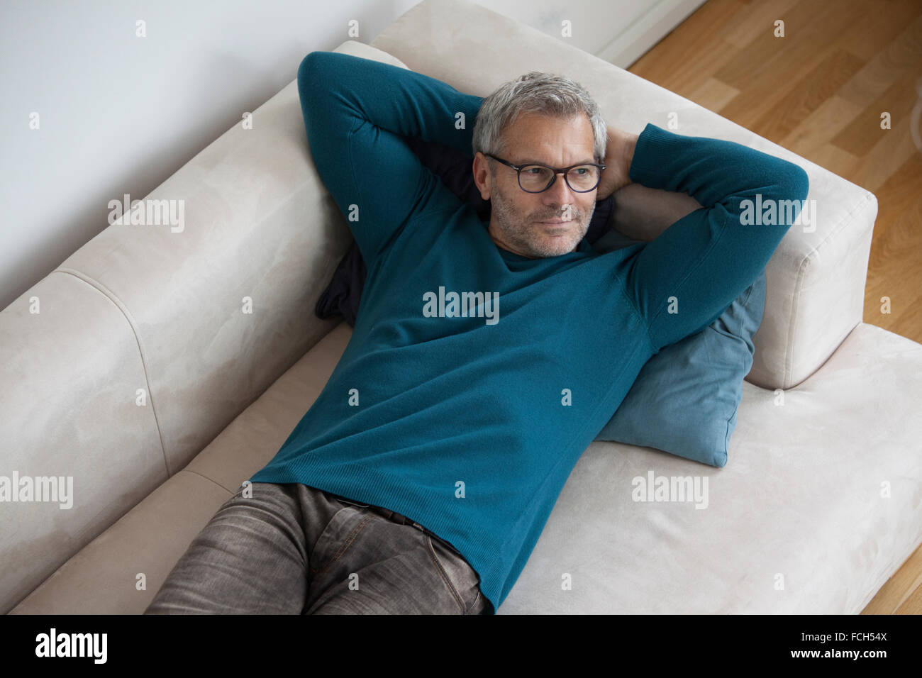 Reifer Mann zu Hause entspannt liegen auf couch Stockfoto
