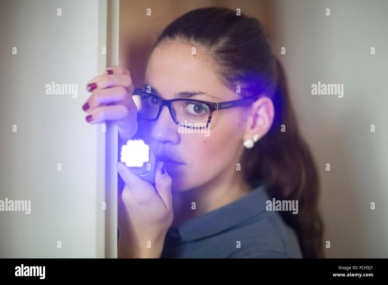 Porträt der Frau leuchtenden LED-Taschenlampe Stockfoto