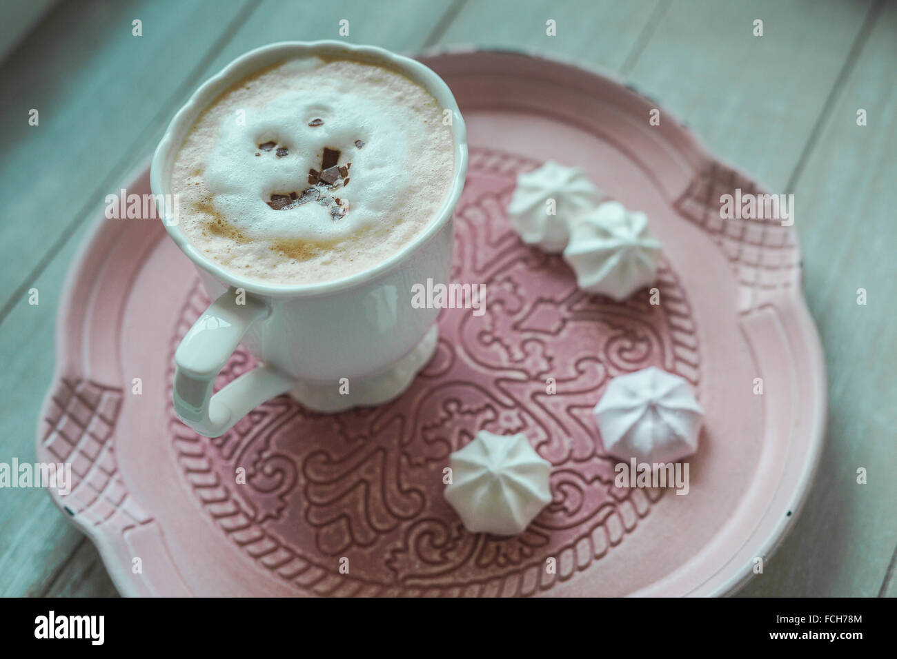 Tasse weißen Kaffee Schokolade rasieren und Meringues auf einem Teller Stockfoto