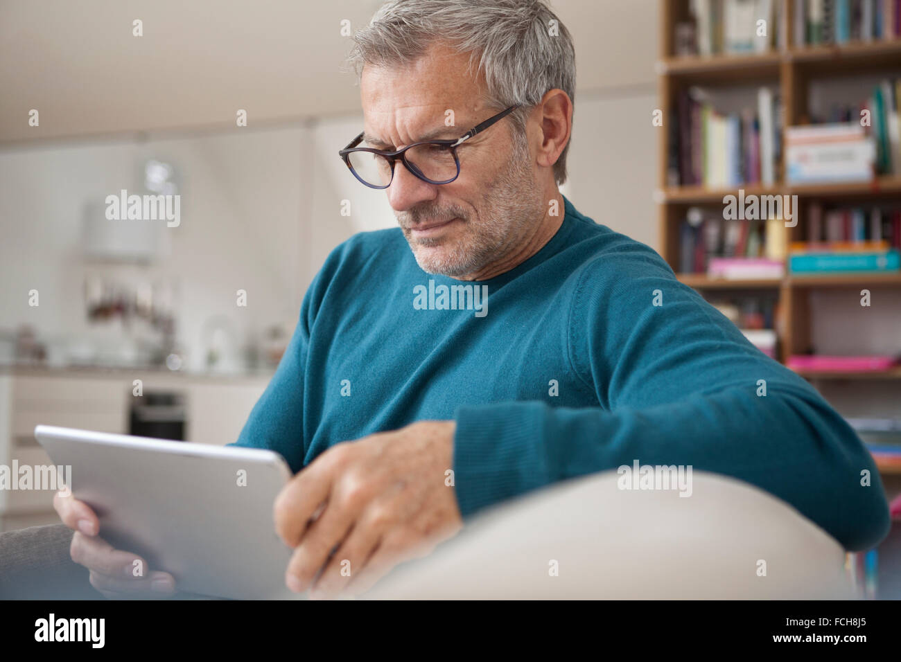 Reifer Mann zu Hause mittels digital-Tablette Stockfoto