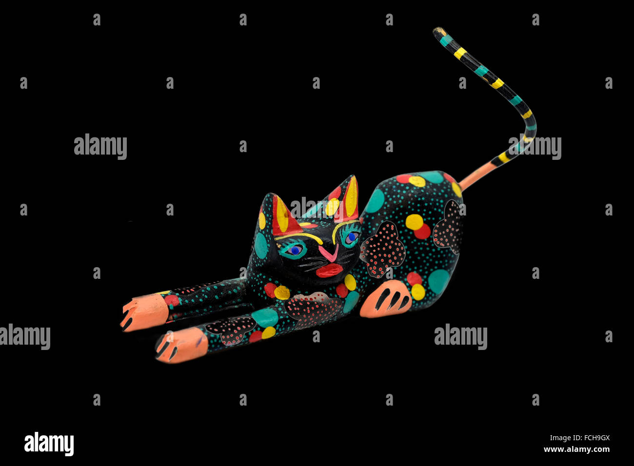 Mexikanische geschnitzten Katze Figur, sehr stilisiert und farbig, Ausschnitt auf schwarzem Hintergrund Stockfoto