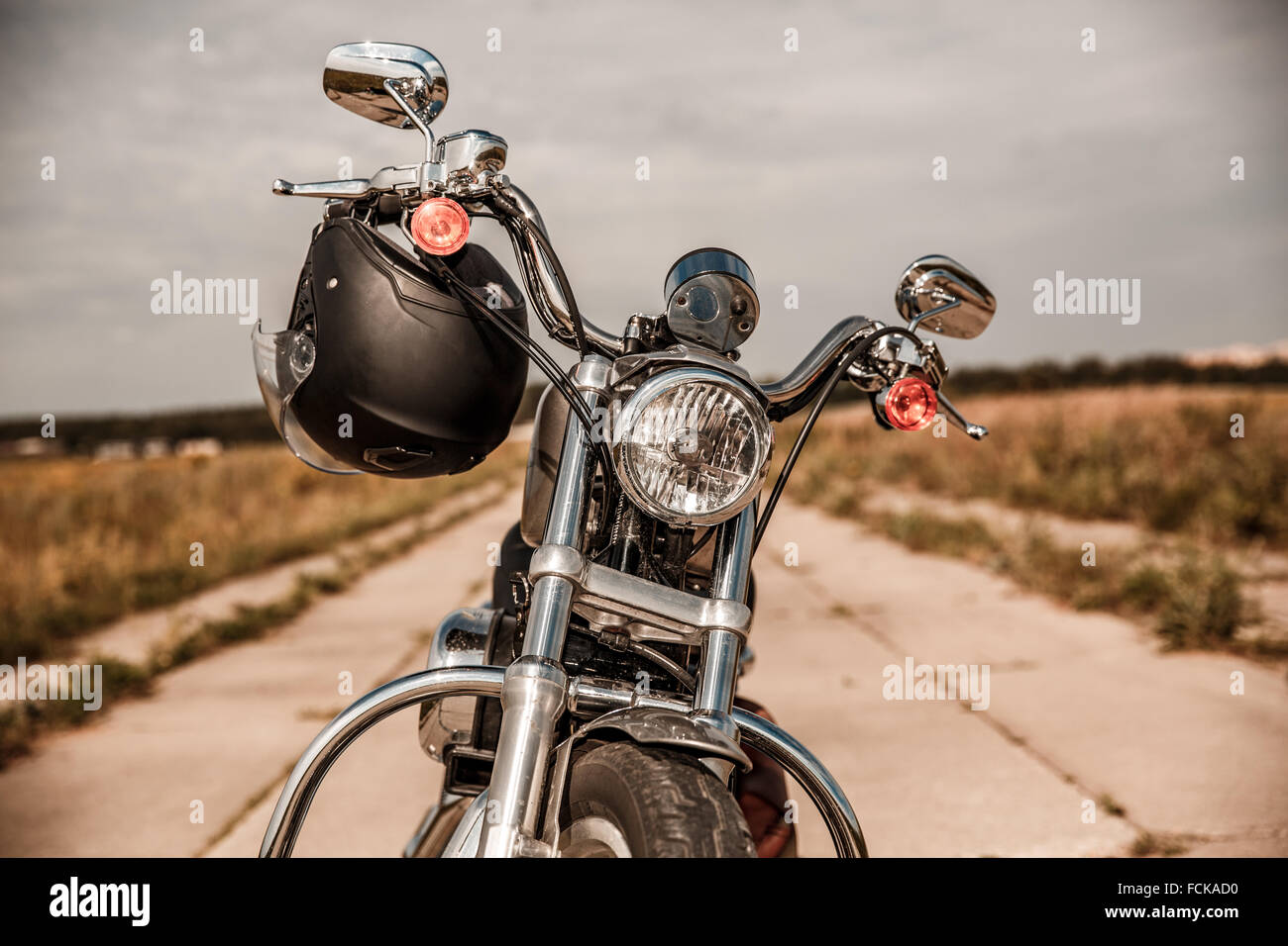Motorrad auf der Straße mit einem Helm auf dem Lenker. Stockfoto