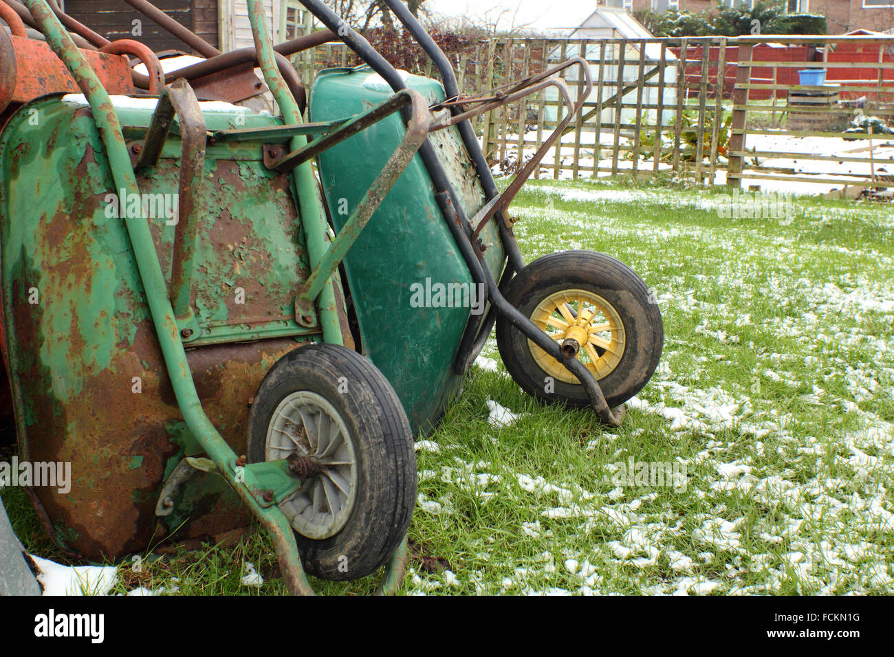 Whhelbarrows gegen eine an einem winterlichen Tag bei einer Zuteilung in Chesterfield Derbyshire UK Schuppen gestapelt Stockfoto