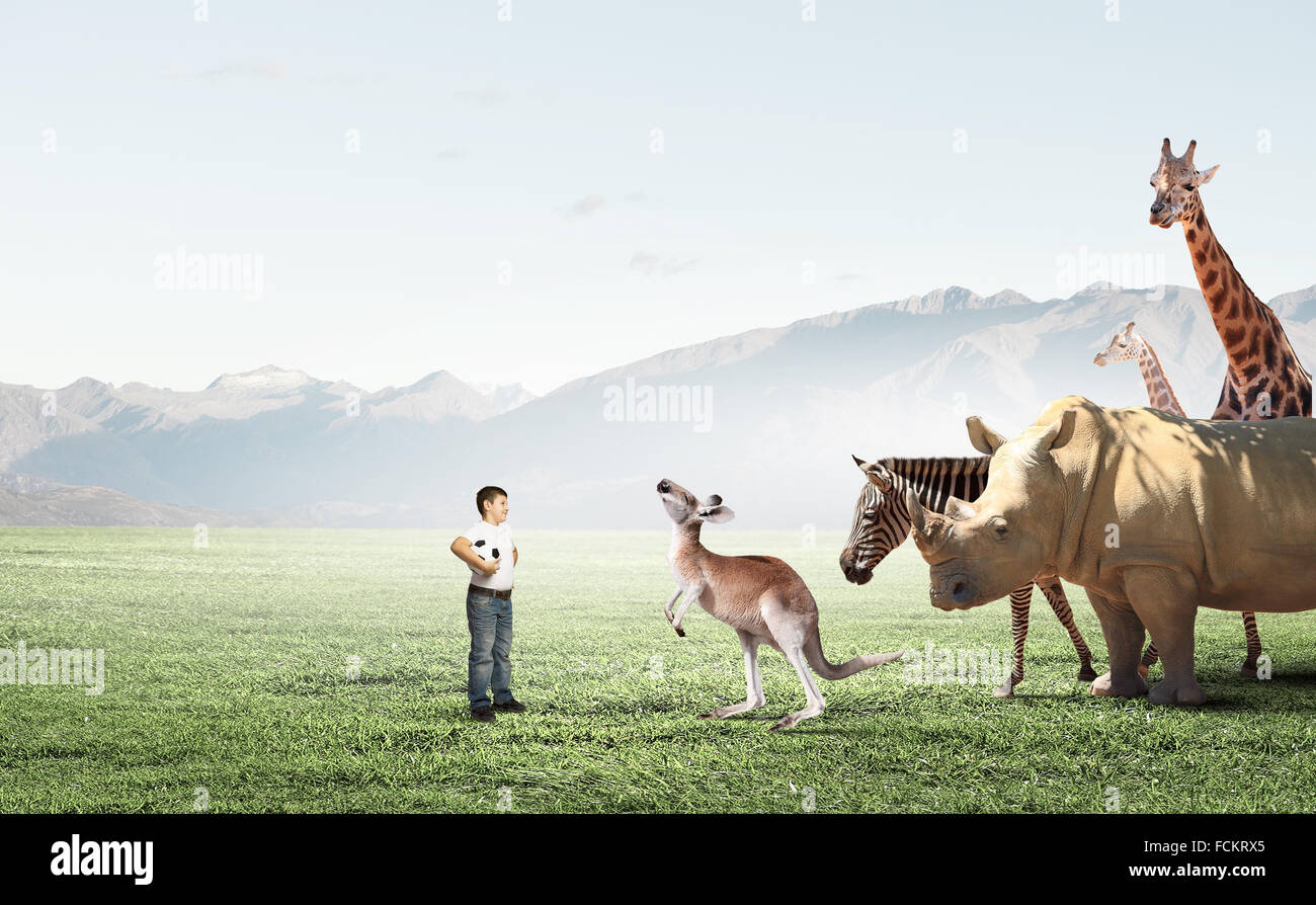 Jungen im schulpflichtigen Alter mit wilden Tieren im freien Stockfoto
