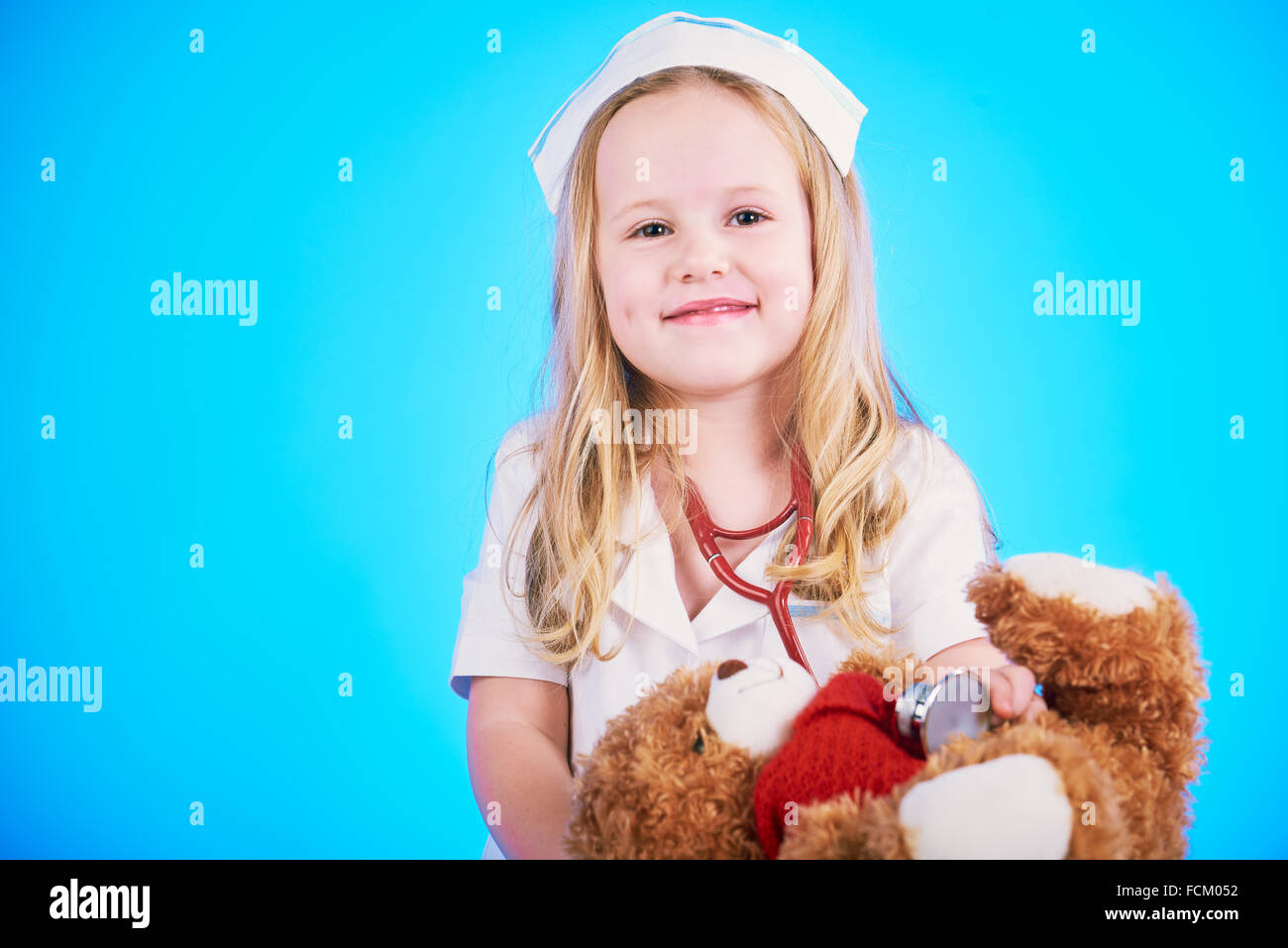 Schöne Krankenschwester Prüfer wenig krank brauner Teddybär. Stockfoto