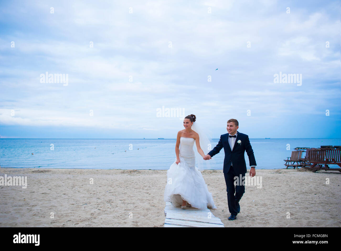 Das Brautpaar sind am Strand spazieren. Stockfoto