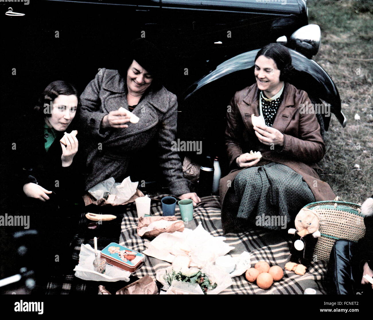 AJAX-NEWS & FEATURE SERVICE. 1926-1930 S (CA.). ENGLAND. -DUFAYCOLOR PICKNICK - DREI DAMEN GENIEßEN EINE AL FRESCO PIC-NIC AUF EINEN TARTAN TEPPICH IN DIESEM DUFAYCOLOR BILD VON EINEM UNBEKANNTEN FOTOGRAFEN ANGELEGT. DUFAYCOLOR WAR EINE FRÜHE ADDITIVE FOTOGRAFISCHEN FARBE TRANSPARENZ SYSTEM POPULÄR IN ENGLAND. FOTO: AJAX VINTAGE BILD BIBLIOTHEK REF: DUFAY PICNIC 01 Stockfoto