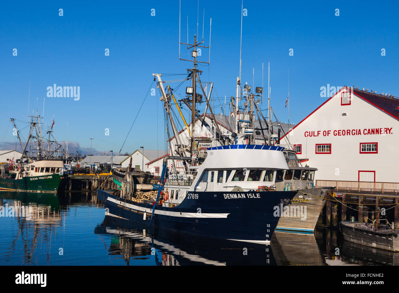 Kommerzielle Fischereifahrzeuge von einer Fisch-Konservenfabrik angedockt Stockfoto