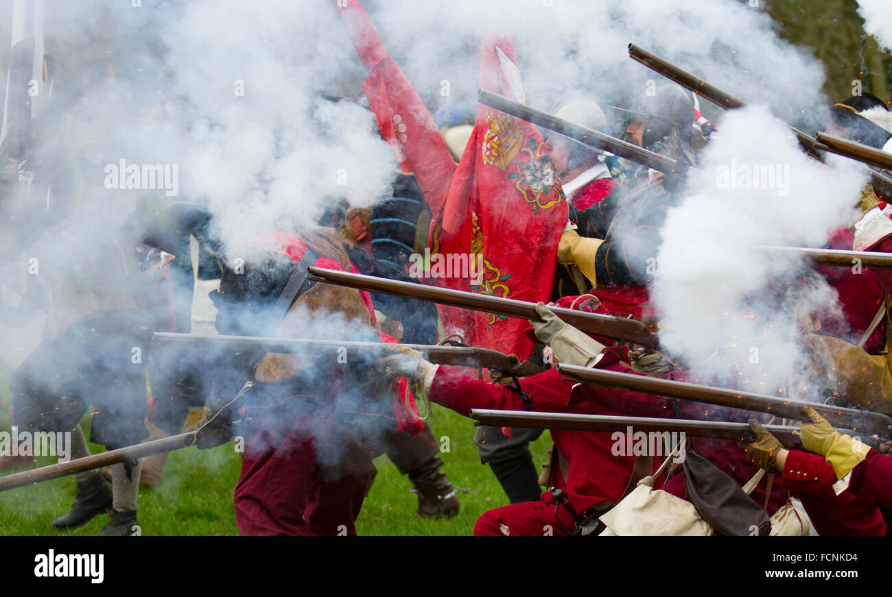 Schwarzpulver schießen in Crewe, Cheshire, UK. Schlacht Fahnen wehen bei der Belagerung von Nantwich Re-enactment. Seit über 40 Jahren den Gläubigen Truppen der versiegelten Knoten in der historischen Altstadt für eine spektakuläre re gesammelt haben - Verabschiedung der blutigen Schlacht, die fast vor 400 Jahren stattfand und markiert das Ende der langen und schmerzhaften Belagerung der Stadt. Roundheads, Kavaliere, und andere historische Animateure converged auf das Stadtzentrum neu zu verordnen, die Schlacht. Die Belagerung im Januar 1644 war einer der wichtigsten Konflikte des Englischen Bürgerkriegs. Stockfoto