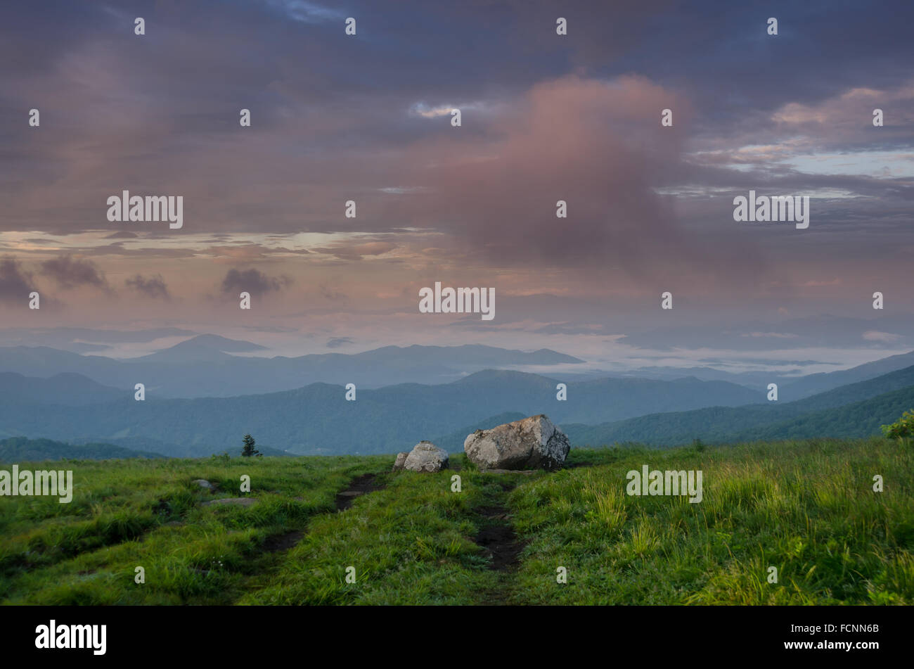 Morgenlicht spiegelt sich in den Wolken über Runde kahle während Nebel weht in den Tälern zwischen den Bergen Stockfoto