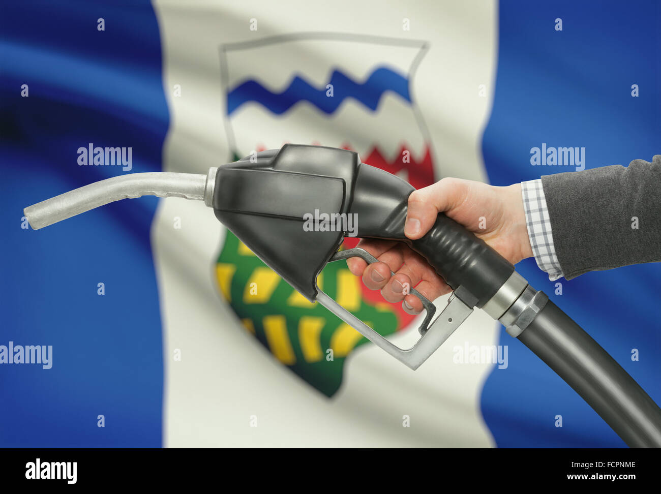 Kraftstoff Pumpe Düse in der hand mit kanadischen Provinzen und Territorien Fahnen auf Hintergrund - Nordwest-Territorien Stockfoto