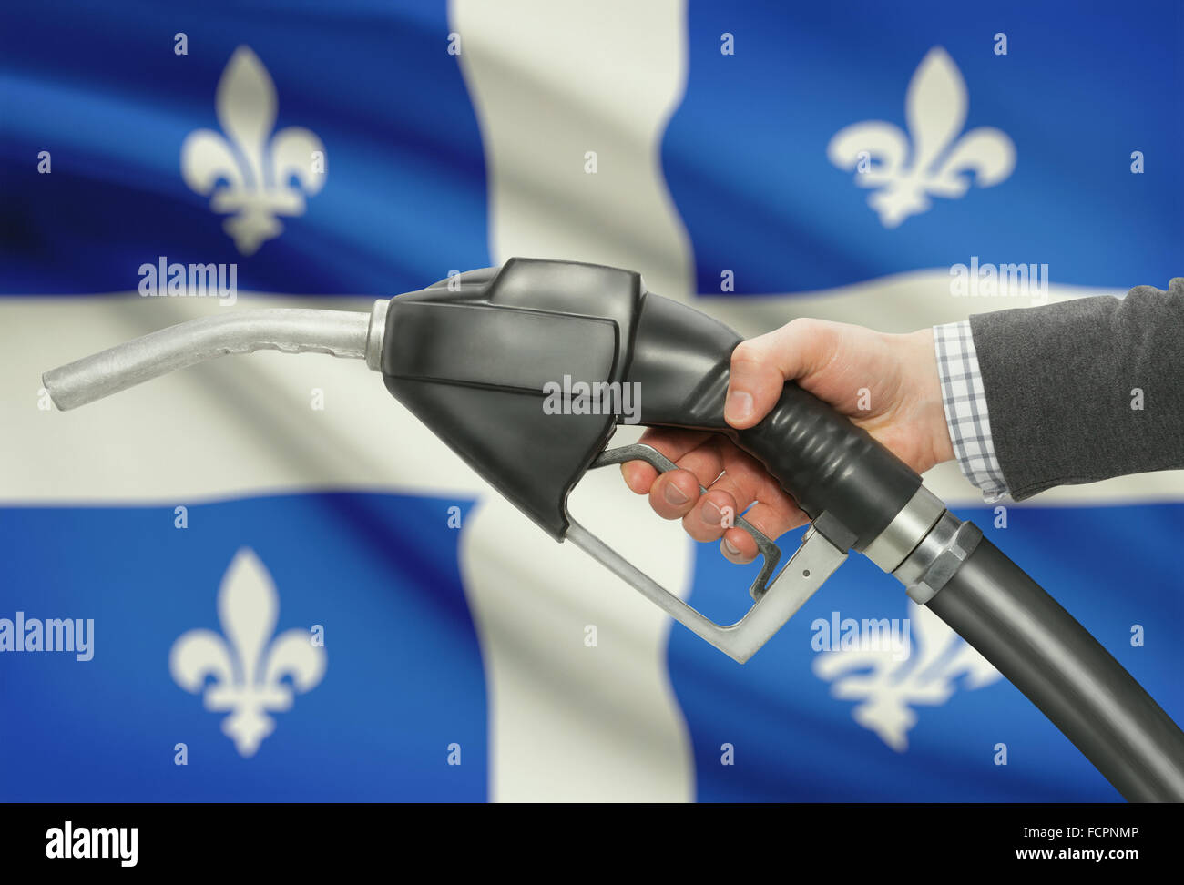 Kraftstoff Pumpe Düse in der hand mit kanadischen Provinzen und Territorien Fahnen auf Hintergrund - Quebec Stockfoto