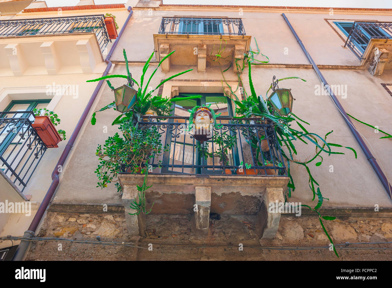 Taormina Balkon, Blick auf eine bunte Ausstellung von Pflanzen und Keramik auf einem Apartment Balkon in einer Straße in der historischen Stadt Taormina, Sizilien. Stockfoto