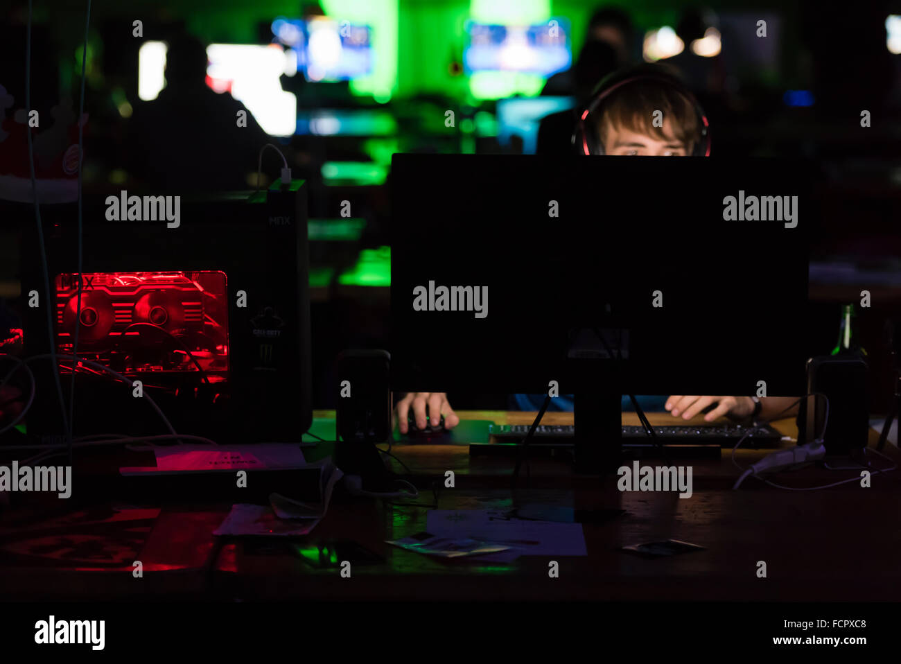 Ein konzentrierter Computer-game-Spieler schwach beleuchtet nur von seinem Computer-Bildschirm auf der größten LAN-Party der Schweiz NetGame 2015. Stockfoto