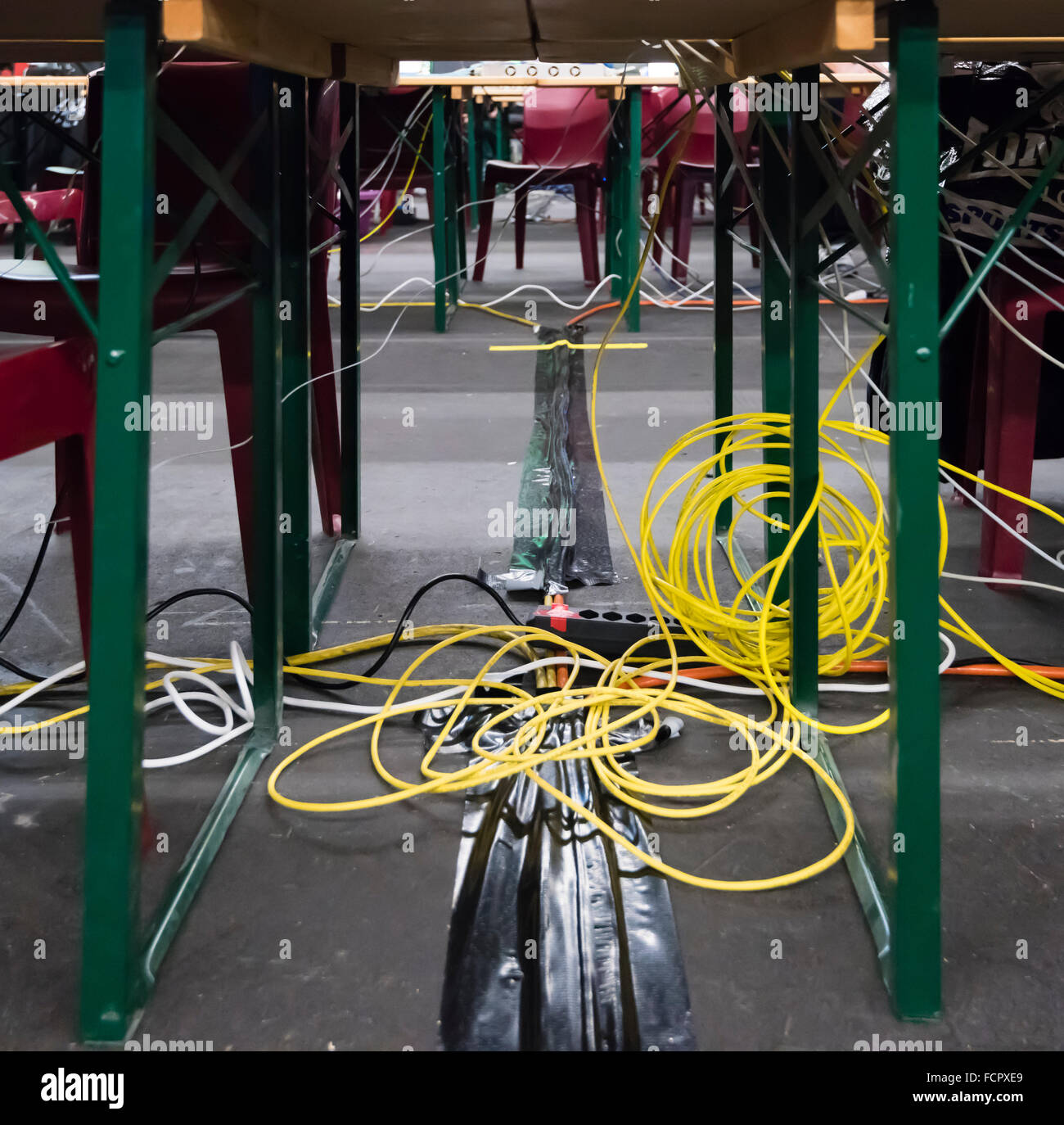 Chaotische Computernetzwerk Verkabelung unter den Schreibtischen bei NetGame Computer Games Convention. Stockfoto