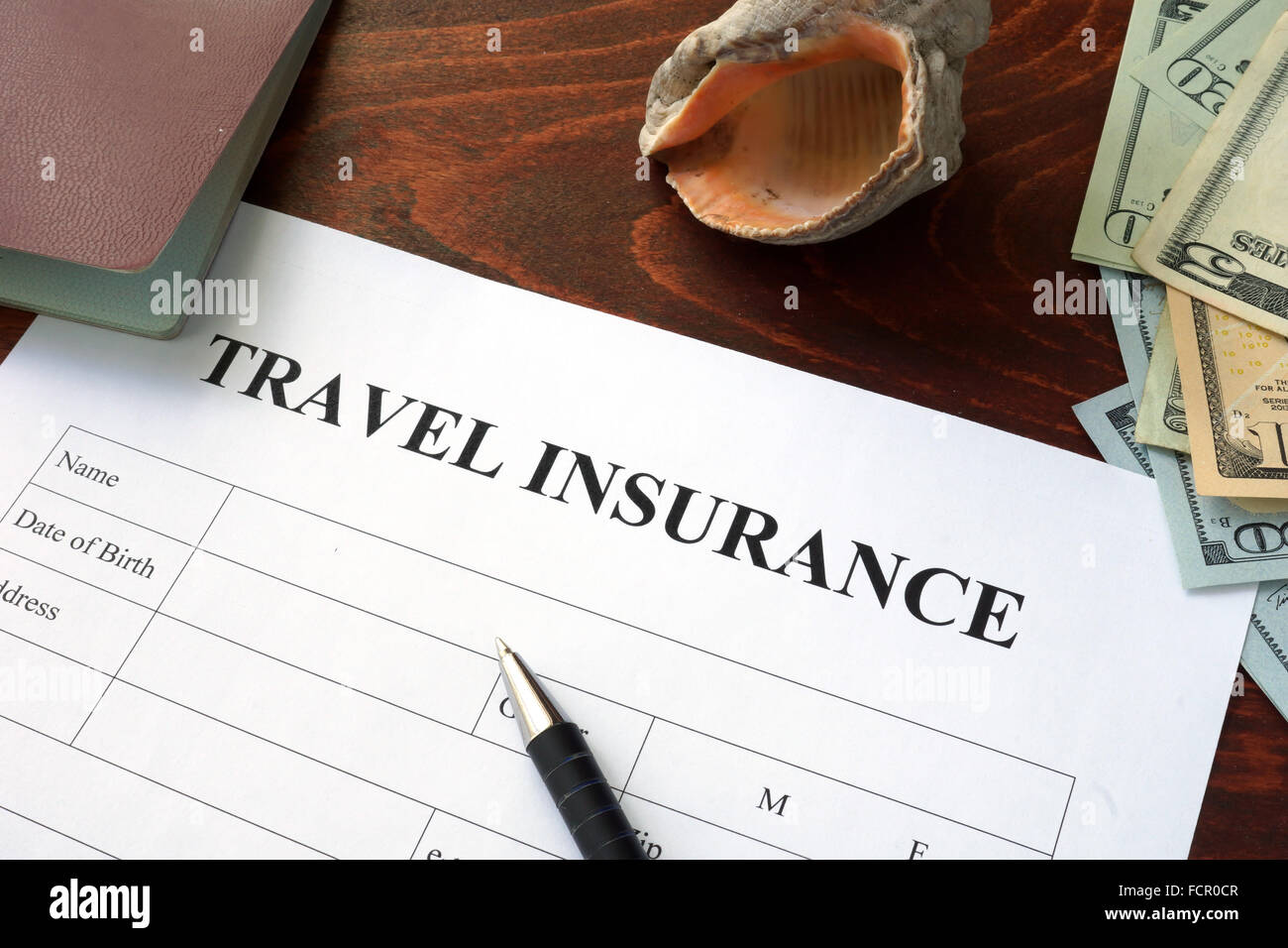 Reise-Versicherungsformular und US-Dollar auf den Tisch. Stockfoto