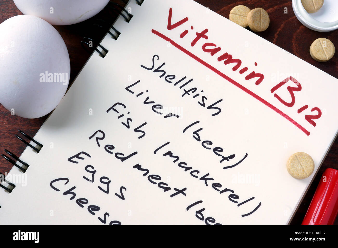 Notizblock mit Vitamin B12 und Pillen auf dem Tisch. Stockfoto