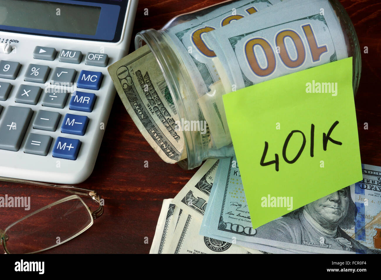 Glas mit Label 401 k und Geld auf den Tisch. Sparen Geld-Konzept. Stockfoto Glas mit Label 401 k und Geld auf den Tisch. Sparen Geld-Konzept. Stockfoto