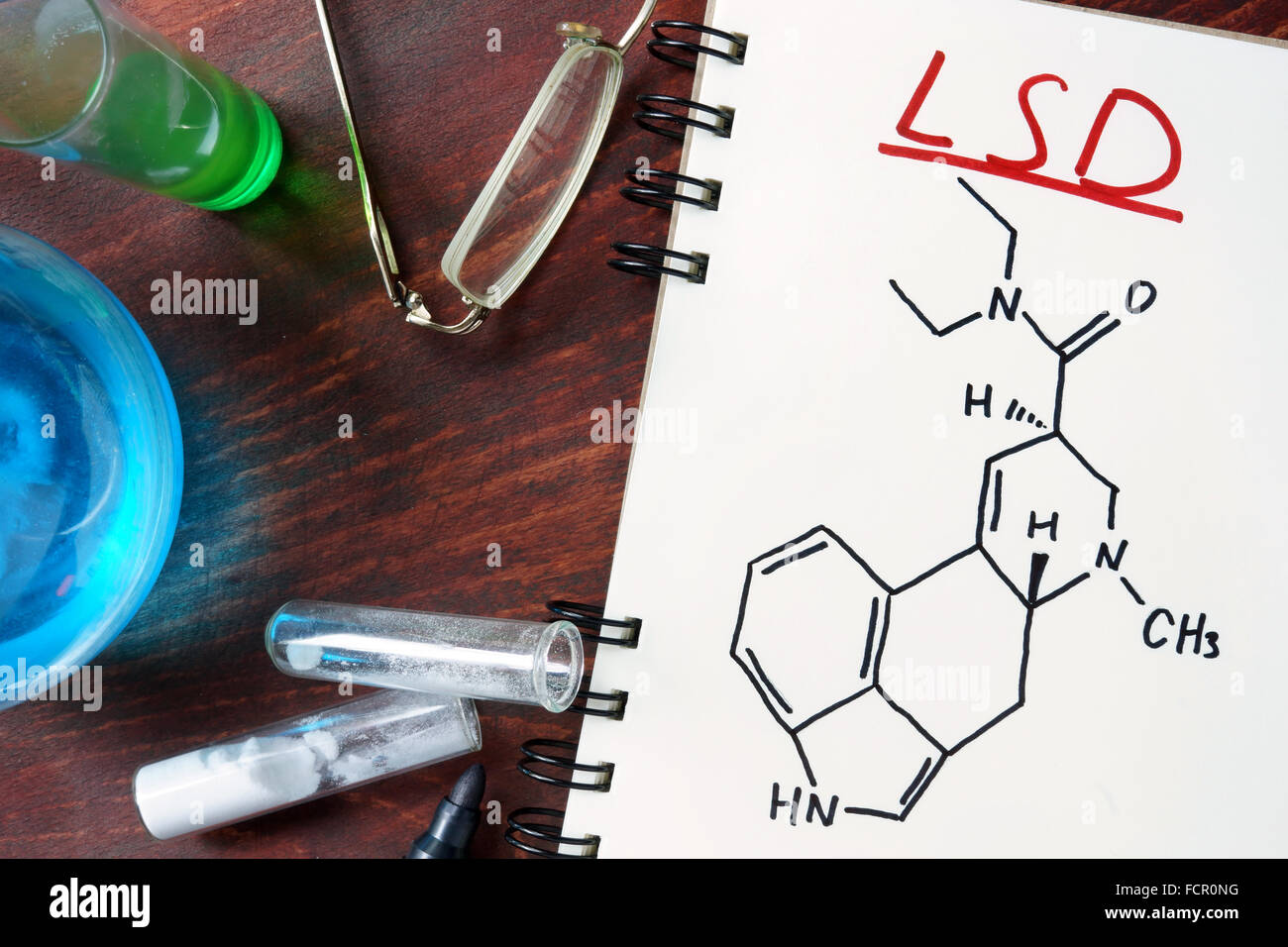 Notizblock mit chemische Formel von LSD auf dem Holztisch. Drogen-Konzept. Stockfoto