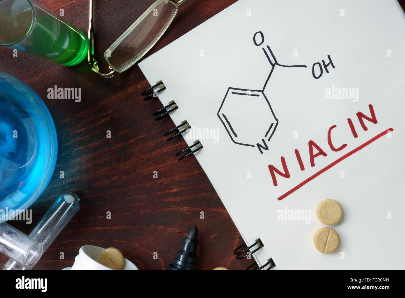 Notizblock mit chemische Formel von Niacin (Vitamin b3) auf dem Holztisch. Stockfoto