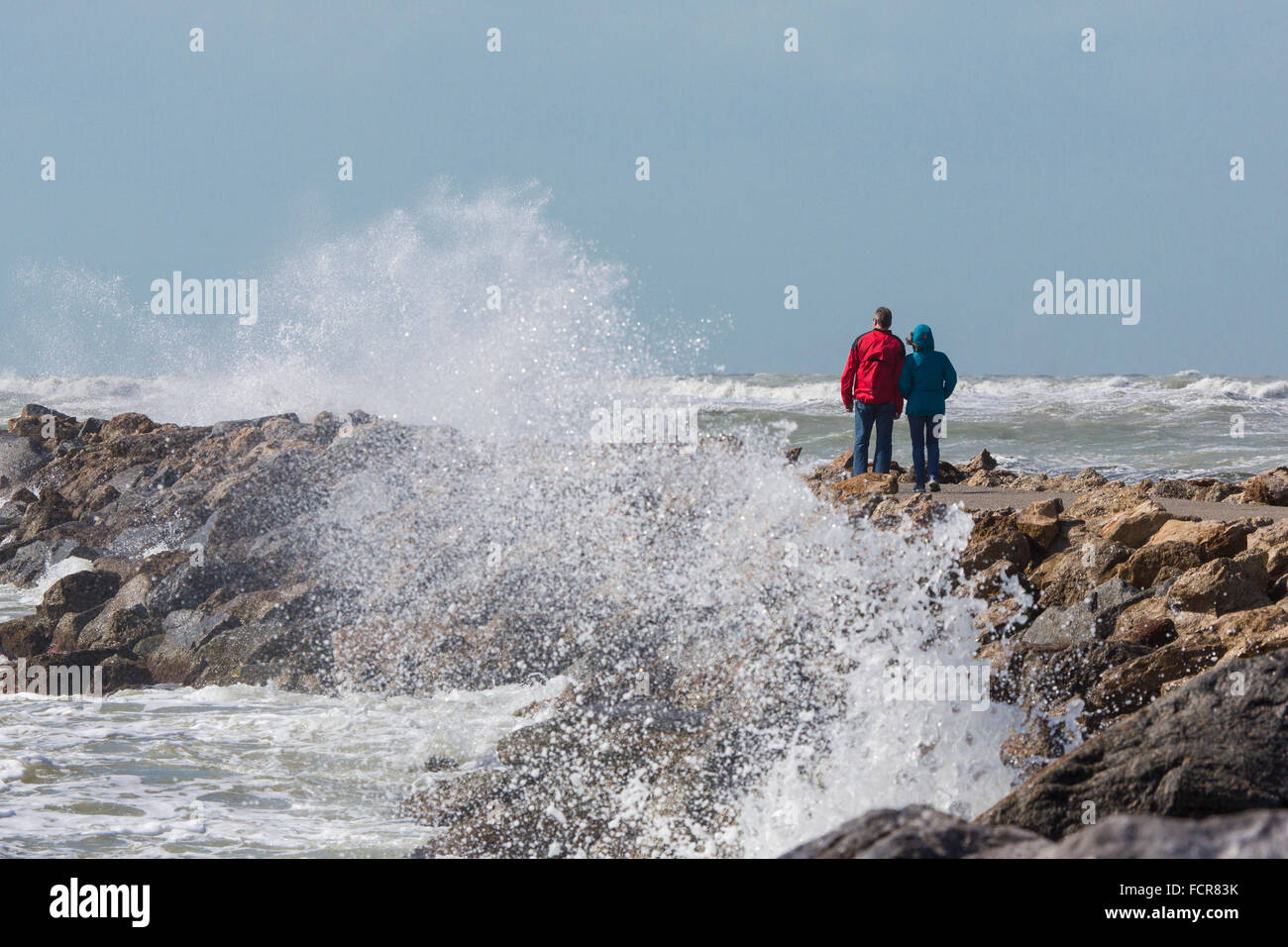 Frau und Mann zu Fuß Hund mit Golf von Mexiko Sturmwellen am südlichen Steg in Venice Florida Stockfoto