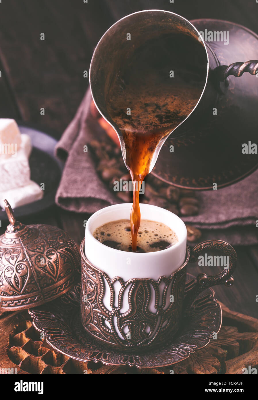 Türkischer Kaffee in traditionellen geprägtem Metall-Tasse Gießen. Getönten Stockfotografie