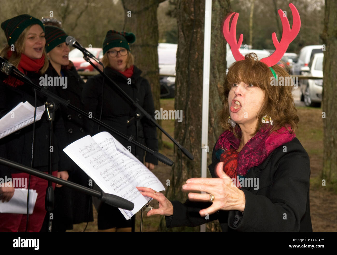 Frau, die Durchführung von "Der kleine Chor" während einer 2015 Weihnachtslied Dienst, Hindhead, Surrey, UK. Stockfoto