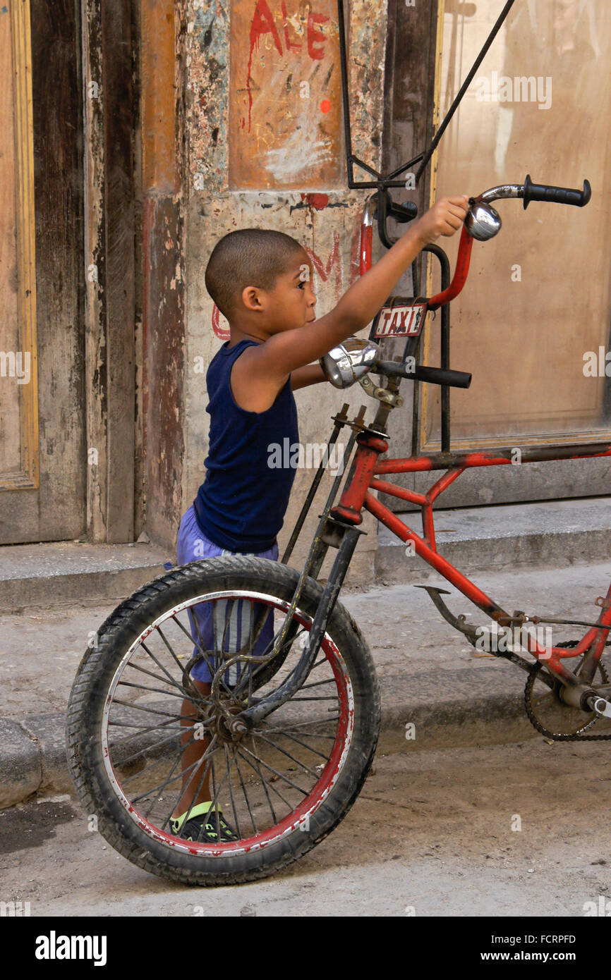 Kleiner Junge spielt mit Fahrrad Taxi, Habana Vieja (Altstadt von Havanna), Kuba Stockfoto