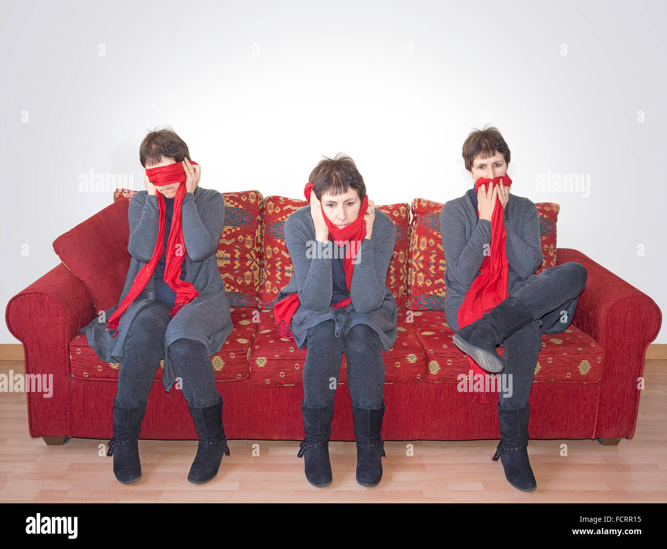 Nichts Böses sehen, nichts Böses hören, nichts Böses sprechen. Reife Frau auf Sofa. Klatsch, etc. Stockfoto