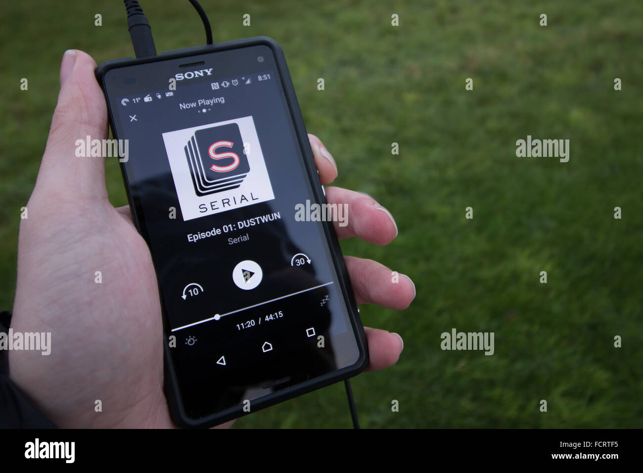 Der podcast Seriennummer auf einem Android Smartphone über die Tasche wirft Podcasting app wird zugehört. Stockfoto