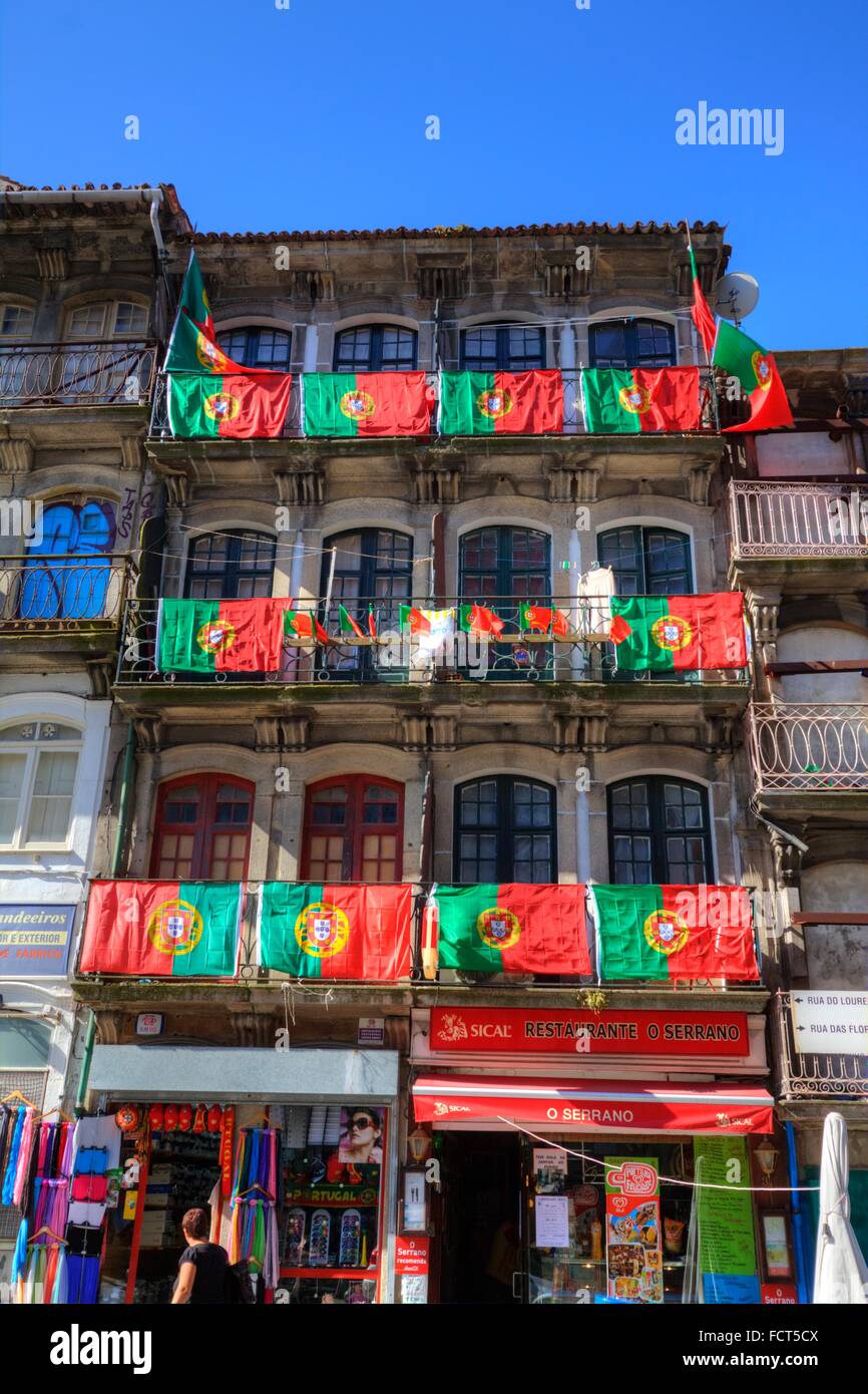 Wohnstraße, dekoriert mit Nationalflaggen, Porto, Portugal mit Touristen und Geschäfte Stockfoto