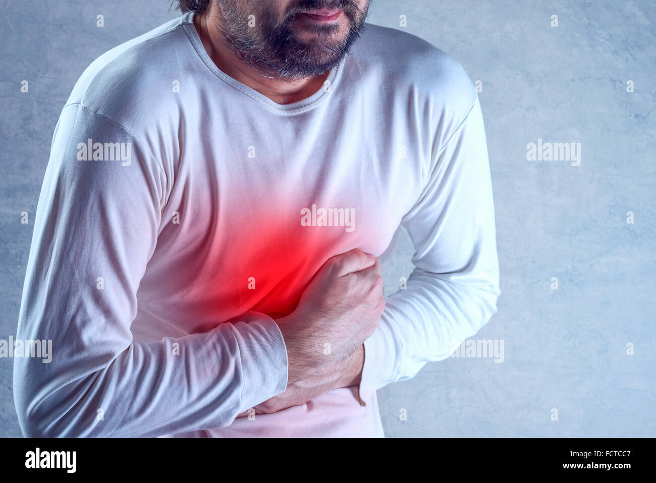 Starke Bauchschmerzen, Mann leidet unter Magenschmerzen, seinen Bauch zu halten und mit schmerzhaften Krämpfen. Stockfoto
