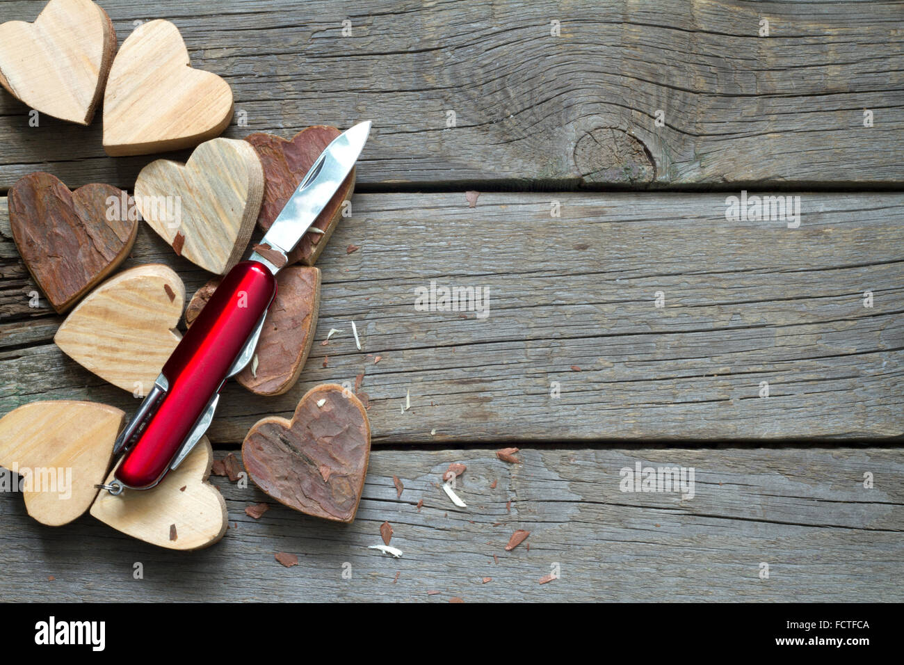 Geschnitzte Holzherzen und Messer Auszug aus Liebe Konzept Stockfoto