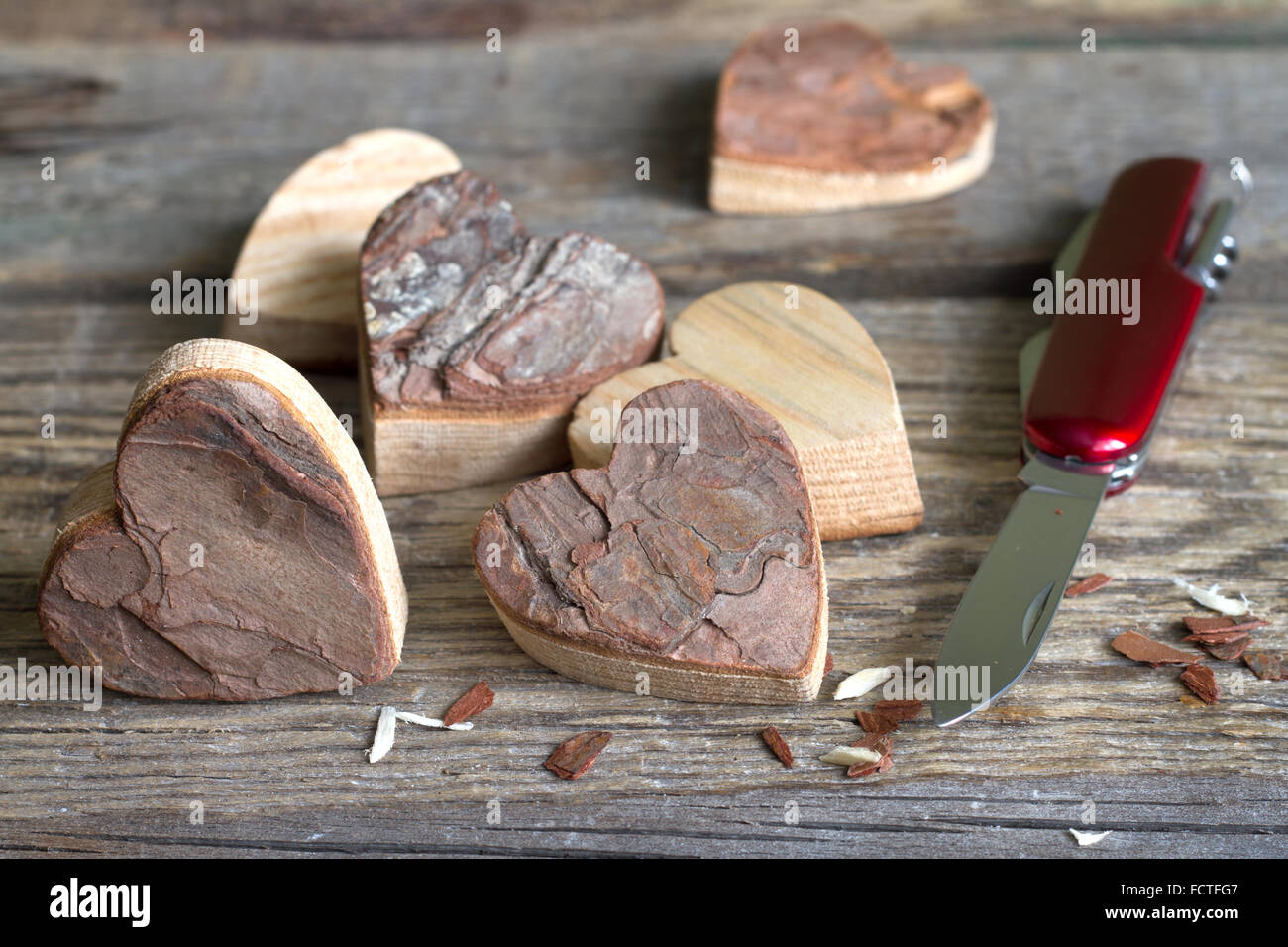 Geschnitzte Holzherzen und Messer Auszug aus Liebe Konzept Stockfoto