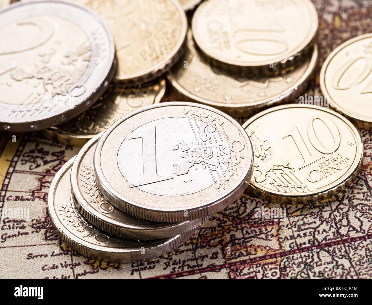 Euro-Münzen über die alte Weltkarte. Makro-Bild. Stockfoto