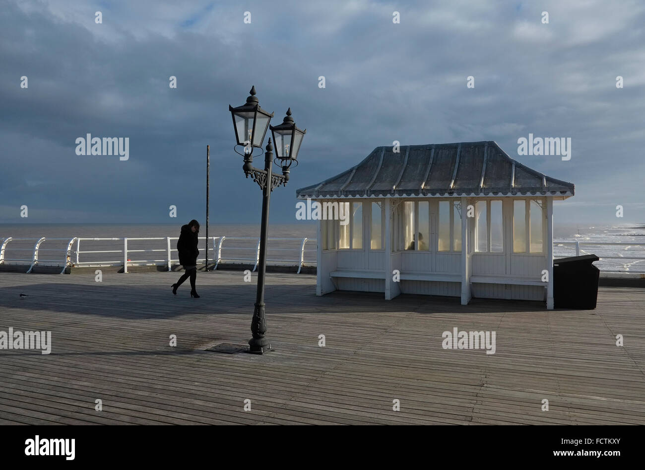 Fußgänger, die bei starkem Wind auf Cromer Pier, North Norfolk, england Stockfoto