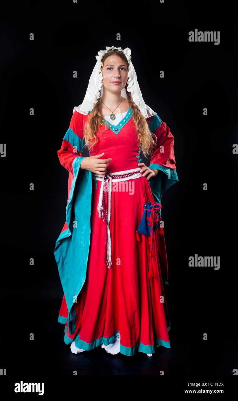 Vordere Studio-Porträt eines Mädchens gekleidet in mittelalterlichen roten Kleid und Kopftuch auf schwarzem Hintergrund Stockfoto