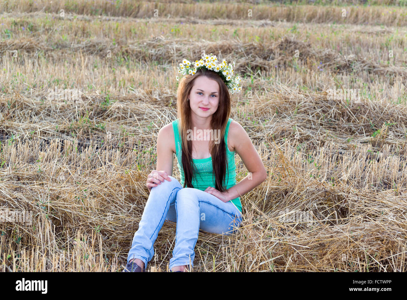 Mädchen mit Kranz aus Margeriten in einem Feld Stockfoto