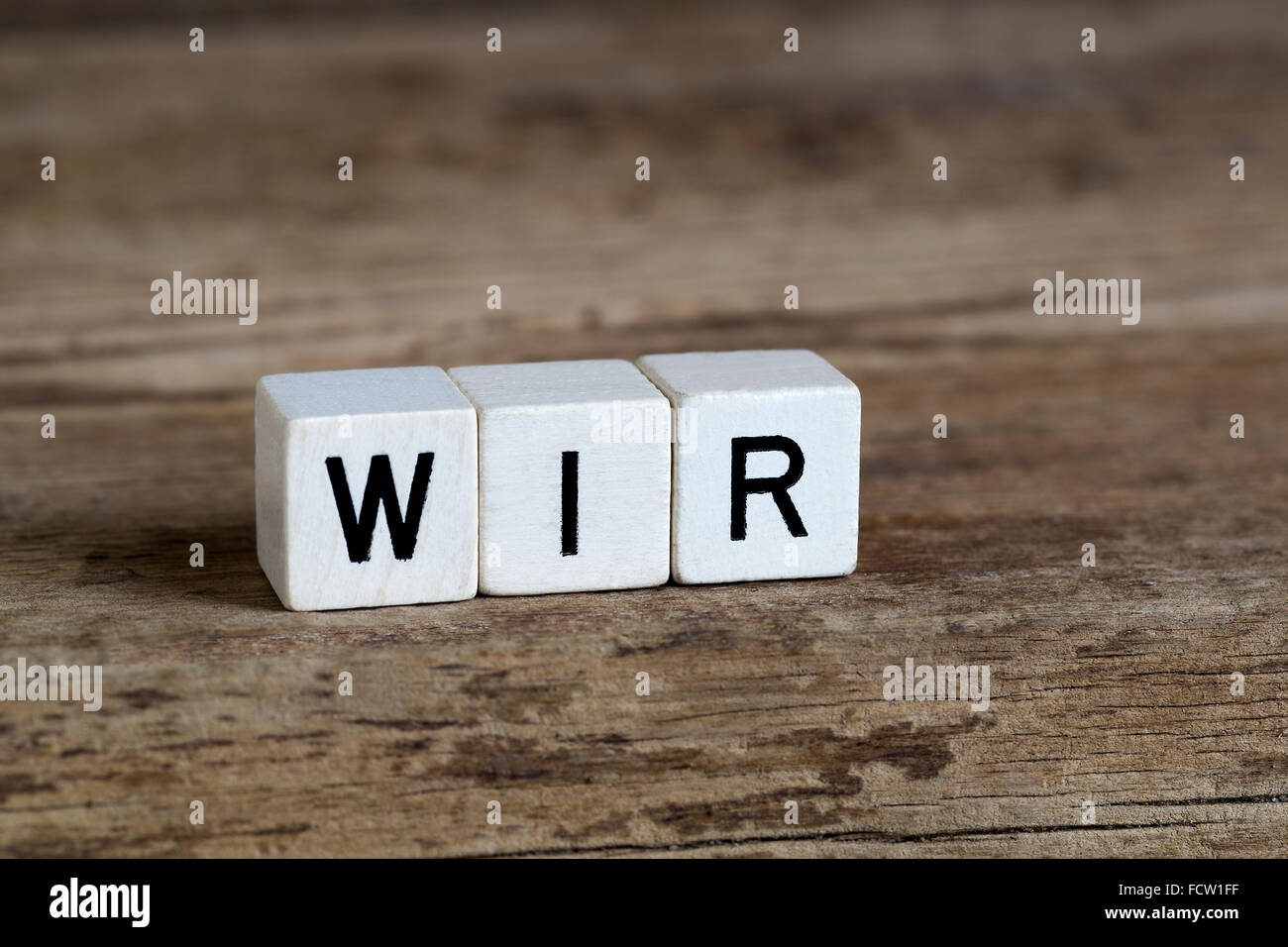 Deutsches Wort Wir in Würfel auf hölzernen Hintergrund geschrieben Stockfoto
