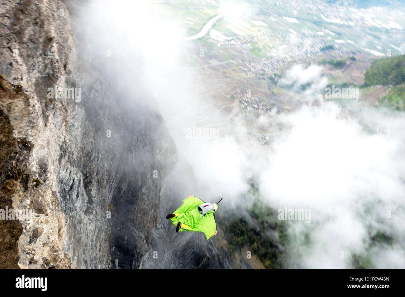 Diese wingsuit Base Jumper nur verlassen von einer Klippe hinunter ins Tal. Er wird seinen Fallschirm kurz vor der Cloud schlagen. Stockfoto