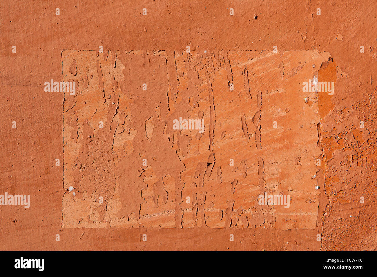 Spuren der alten Ankündigungen auf Terrakotta bemalten Stuck Wand gesehen. Hintergrundtextur. Stockfoto