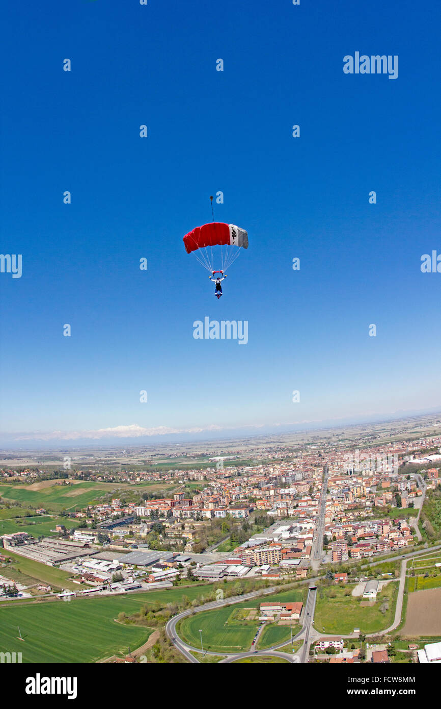 Fallschirm-Springer fliegt unter seinem Baldachin über eine Stadt in Italien. Dabei sucht er nach der engagierten Landeplatz nach unten heraus. Stockfoto